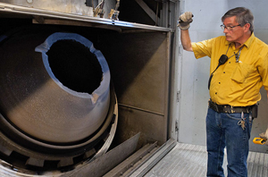 A staff member of AECOM with the Anniston Static Detonation Chamber to be used at the PCAPP.