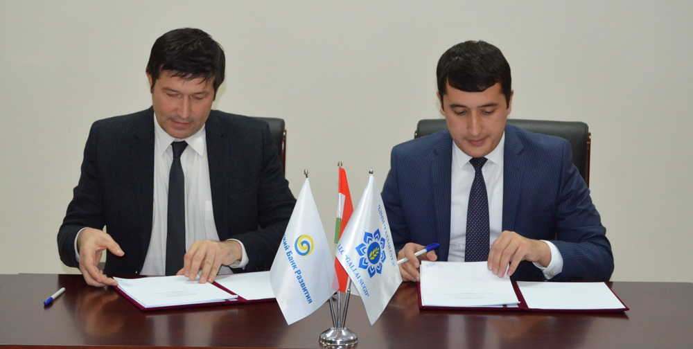 Rashid Kadyrov, left, director of the EDB Representative Office in Dushanbe, and Farhod Kurbonov, general director of Gallai Sugd, sign financing lease agreements for EBD's investment in the Tajik wheat market.