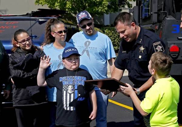Eleven-year-old Drake Price, who is receiving treatment for a brain tumor, was sworn in as a junior DuPage County deputy for the day by Undersheriff Frank Bibbiano.