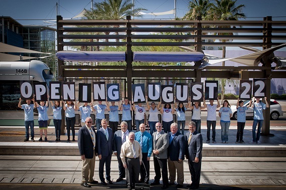 Local officials pose in front of the Center/Main Street station with members from the Mayor’s Youth Committee to reveal the Central Mesa extension's Aug. 22 opening date.