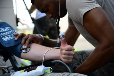 Senior Airman Akil Oohoa checks the remperature and heart rate of a participant in a training exercise at Osan Air Base in South Korea.