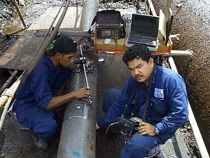 Technicians inspect a PETRONAS pipe using NDT methods in order to test the quality of the pipeline.
