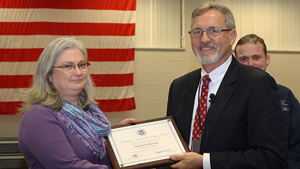 Babbette Harman is presented a Secretary of Homeland Security Award for Unity of Effort for her service in the Ebola Worldwide Response effort from CDP Superintendent Mike King.