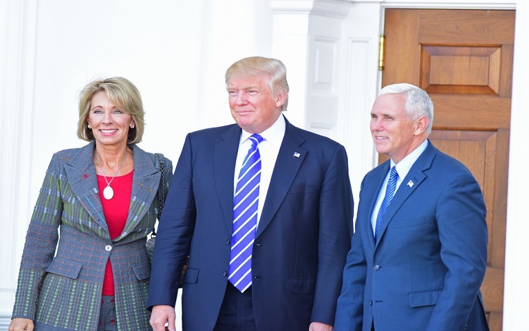 Betsty DeVos with Donald Trump and Mike Pence